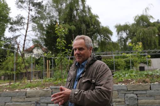 Gartenplaner Peter Richard vor dem neu angelegten Nutzgartenbereich im umgestalteten Rosengarten. Die Trockenmauern bieten Lebensräume für Tiere und Pflanzen. 